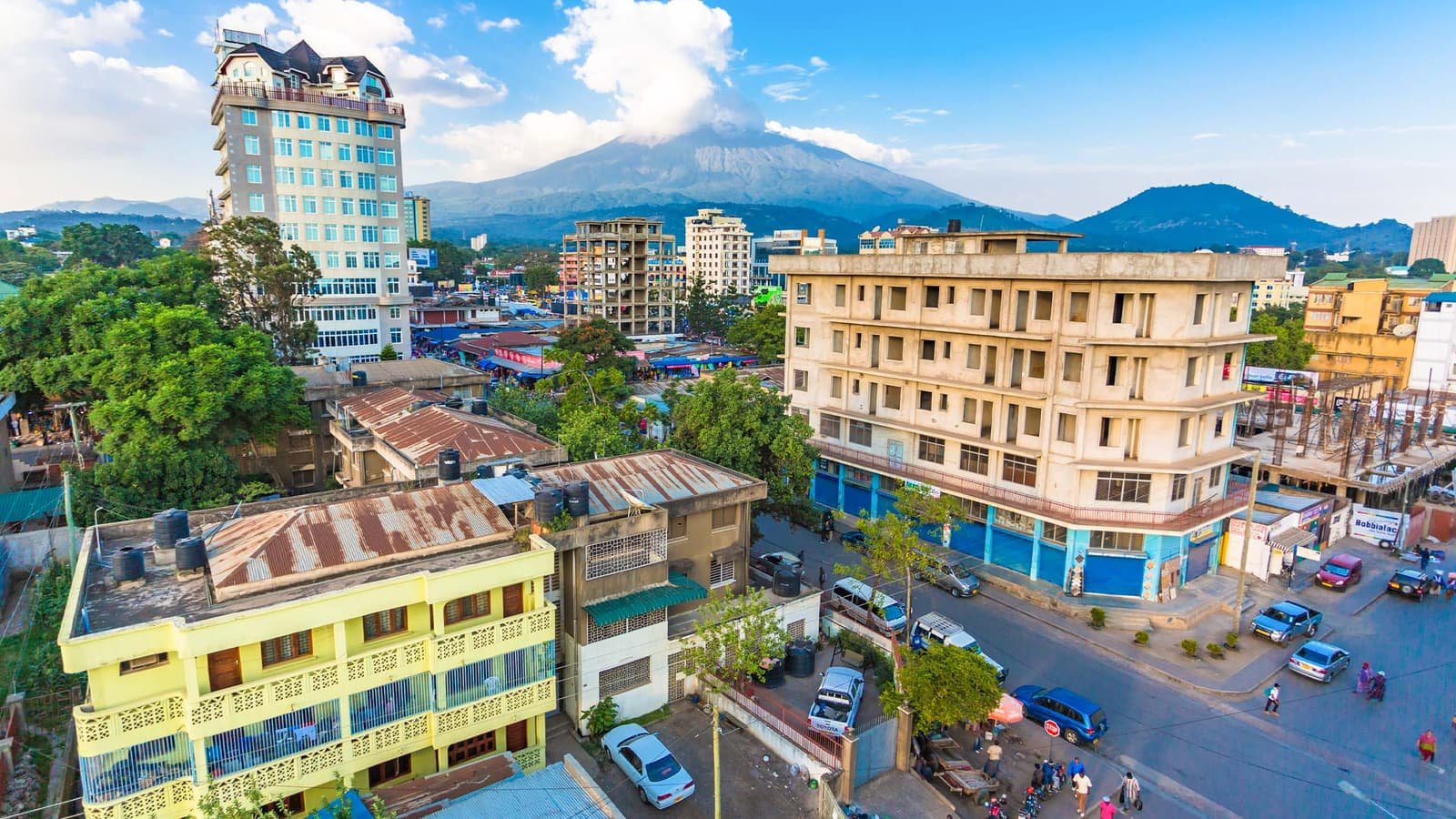 Rooftops and a busy street in the centre of Arusha, with Mount Meru rising behind the town