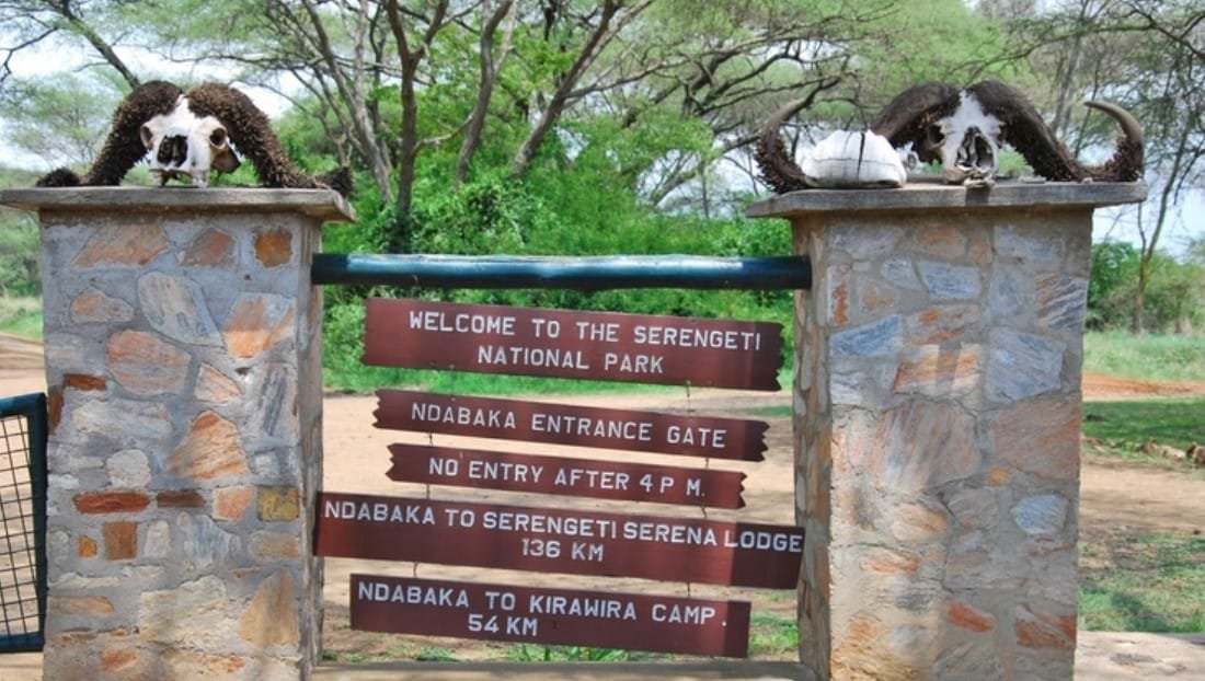 The welcome sign at the Ndabaka entrance gate, listing the distances to Serena and Kirawira