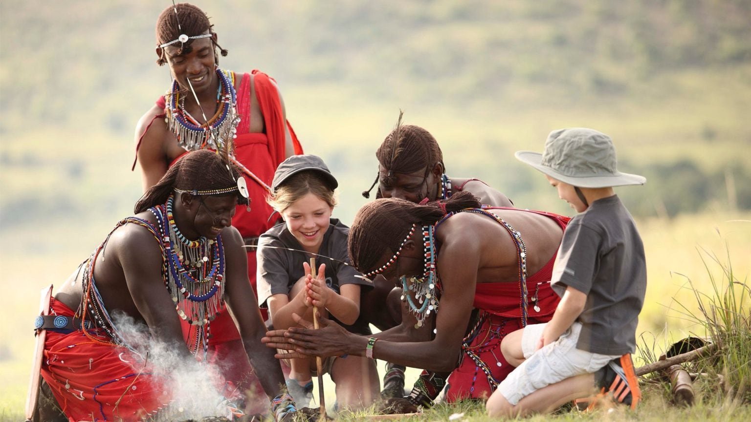 Maasai guides showing children how to make fire with sticks